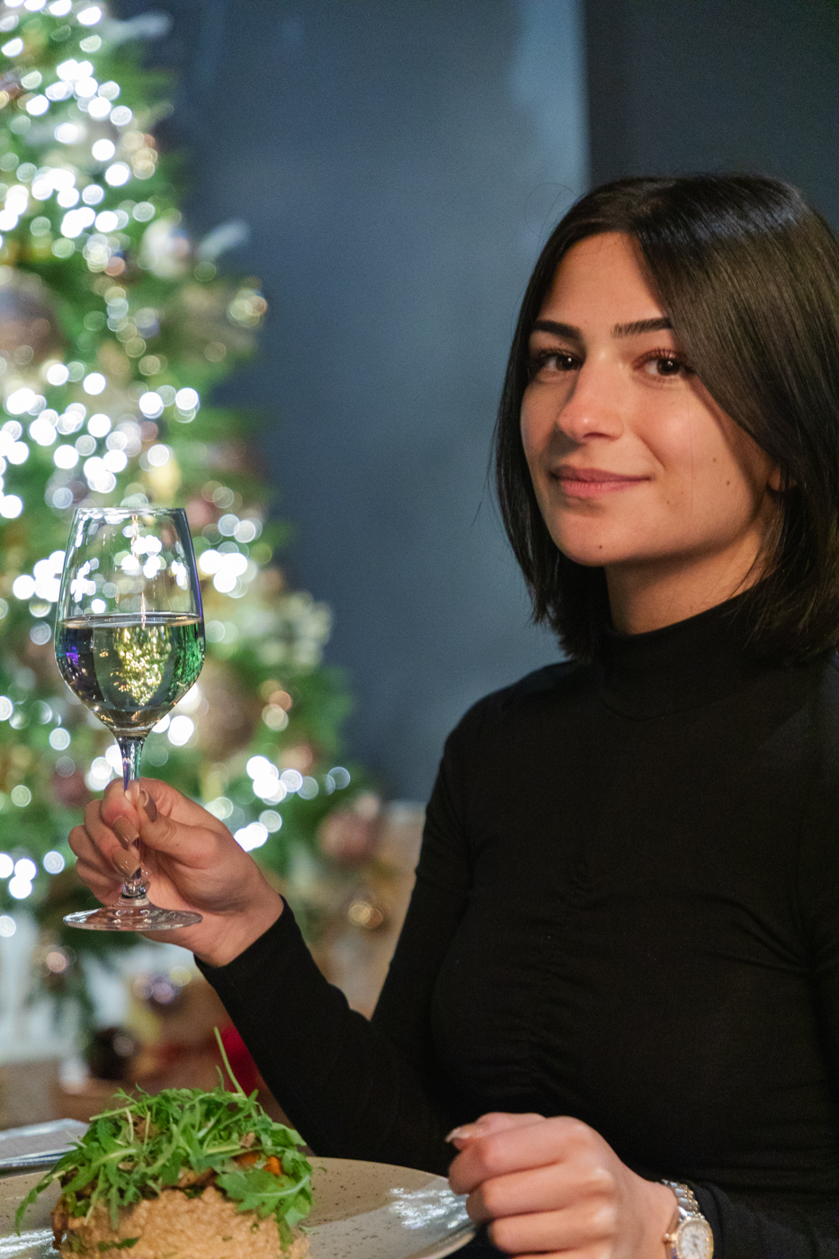 Girl with a glass of white wine having dinner in restaurant